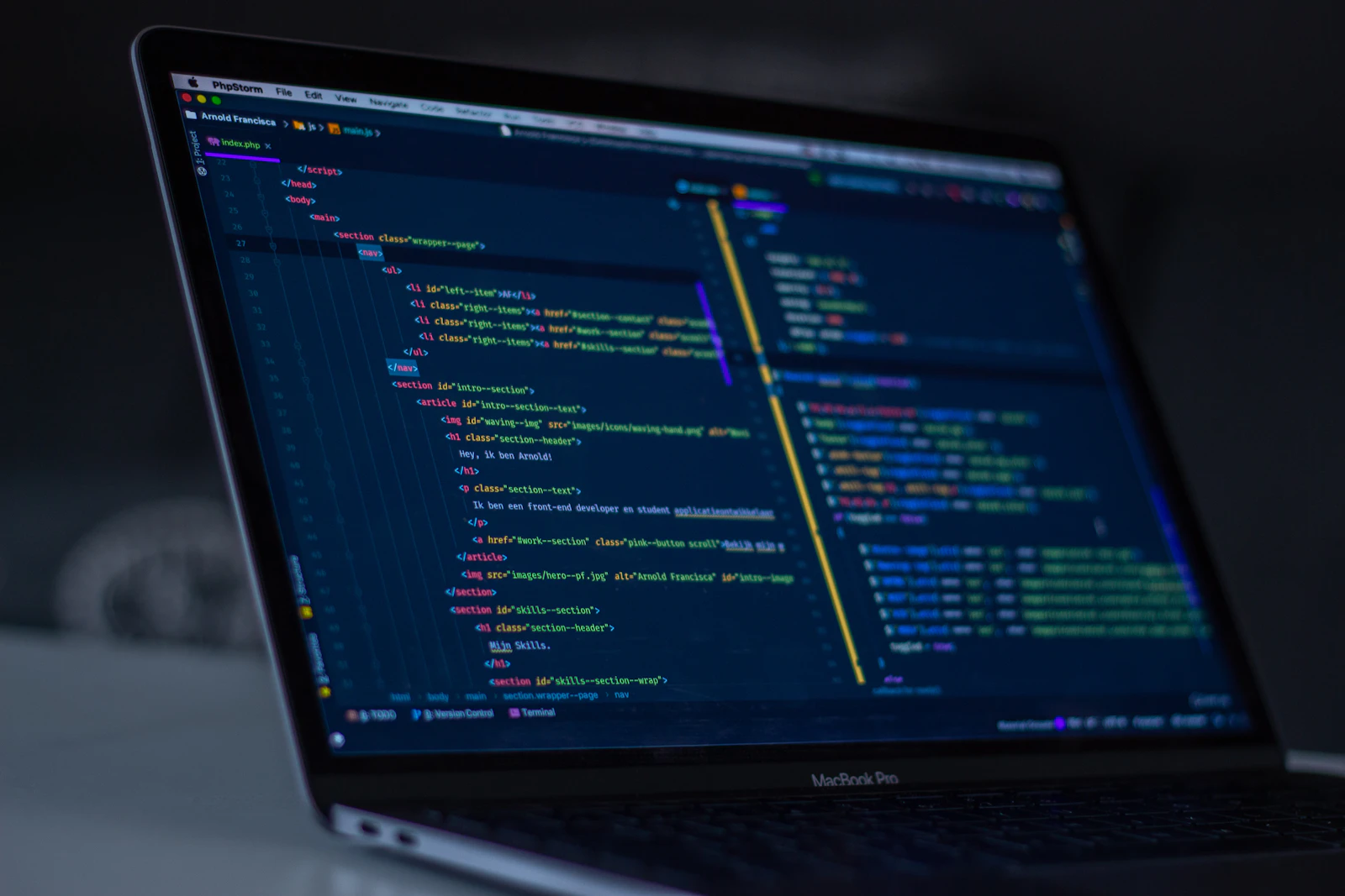 Pantalla de MacBook Pro con código de programación, desarrollo de ecommerce a medida con carrito de compras en PHP