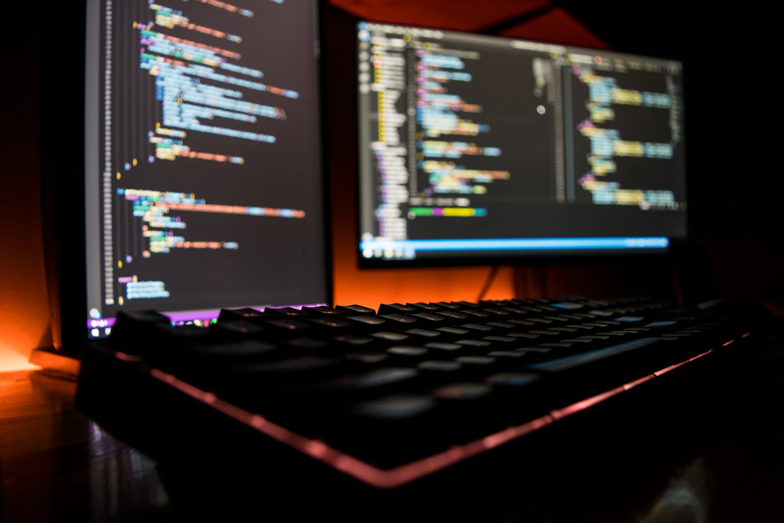 Teclado de computador con luces de colores sobre un escritorio, imagen de desarrollo de software a medida